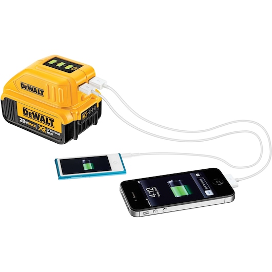 A DEWALT 20V MAX XR lithium-ion battery with a USB adapter is shown charging two electronic devices, a smartphone and a portable music player, using white USB cables.