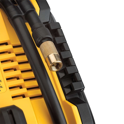Close-up of a DEWALT portable inflator with a brass threaded hose connector and black hose attached to a yellow and black device housing.