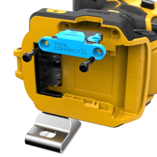 Close-up of a yellow DEWALT power tool showing its open battery compartment with a blue TOOL CONNECT module, attached with two black screws.