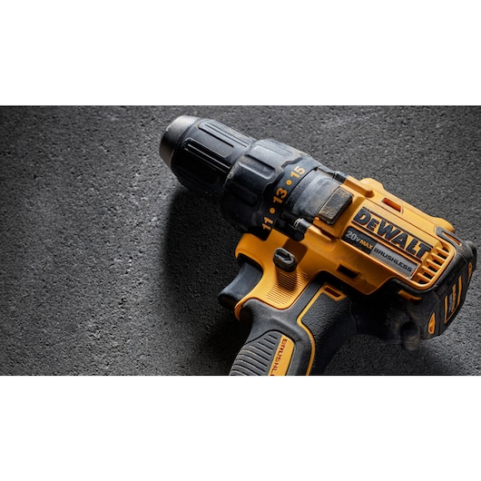 A close-up view of a yellow and black DEWALT 20V MAX cordless drill resting on a textured dark surface.