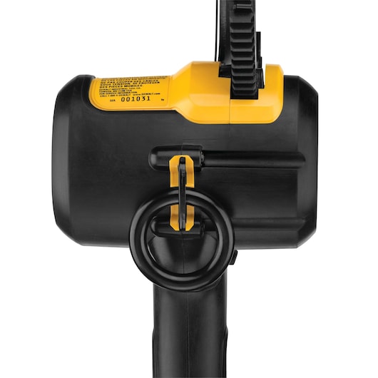 Close-up of a DEWALT power tool, primarily black and yellow, showing the battery compartment and locking mechanism from the side. The tool has a circular handle and visible model information label.