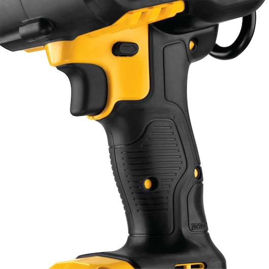Close-up view of the handle and trigger of a DEWALT power tool, featuring a textured black and yellow grip and a side switch.