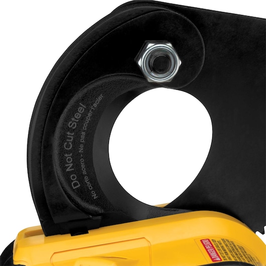 Close-up image of a DEWALT power tool, showing a circular cutting guard with a warning label that states 'Do Not Cut Steel' in English and Spanish. The tool features a yellow body and part of the blade and safety cover are visible.