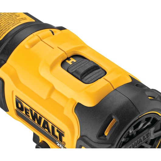 Close-up of a yellow and black DEWALT handheld tool, showing a detailed view of the handle and switch mechanism.