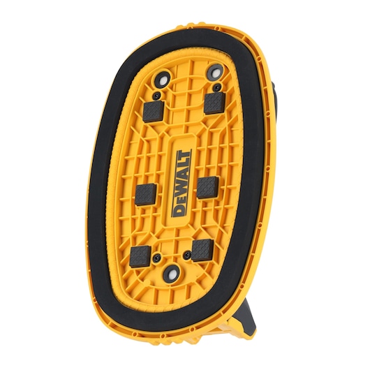 Close-up view of a yellow DEWALT-branded device with a textured oval base and black rubber edge. The item appears to be a mounting or support accessory, featuring multiple screw holes and raised black grip pads.