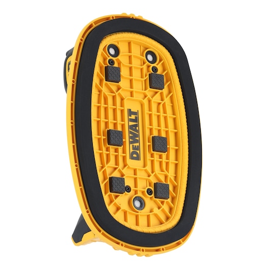 Close-up of the bottom side of a DEWALT yellow and black portable work light with a textured base and rubber pads.