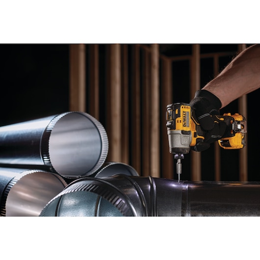 XTREME Brushless cordless impact driver fastening screw in ventilation pipe.