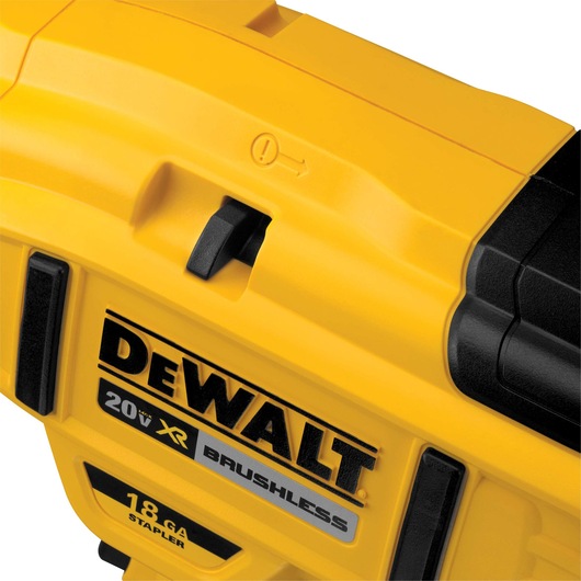 Close-up view of a yellow DEWALT 20V XR brushless 18 gauge stapler, showing branding and part of the switch mechanism.
