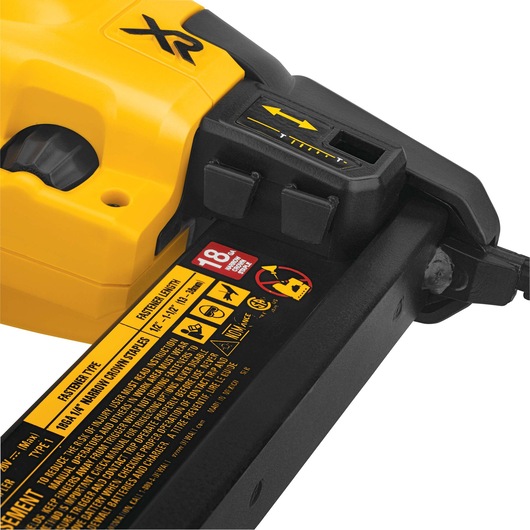 Close-up view of a DEWALT XR cordless nailer showing detailed product labeling, safety warnings, adjustment settings, and part of the magazine housing. The tool is yellow and black with visible instructions and icons.