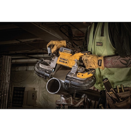 XR Brushless Deep Cut Band Saw being used by worker to cut metal pipe at worksite