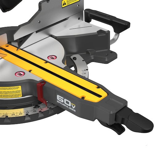 Close-up view of a DEWALT 60V Max Brushless miter saw, showing the blade, handle, measurement gauge, and warning labels.