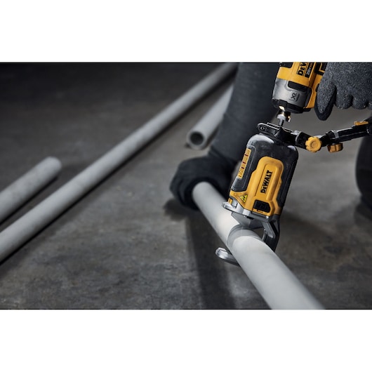 End user using DEWALT IMPACT CONNECT PVC/Pex Cutter attachment on Impact Driver to cut PVC pipe.