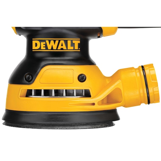 Close-up view of a DEWALT electric sander featuring a yellow and black design, showing the sanding pad and dust extraction port.