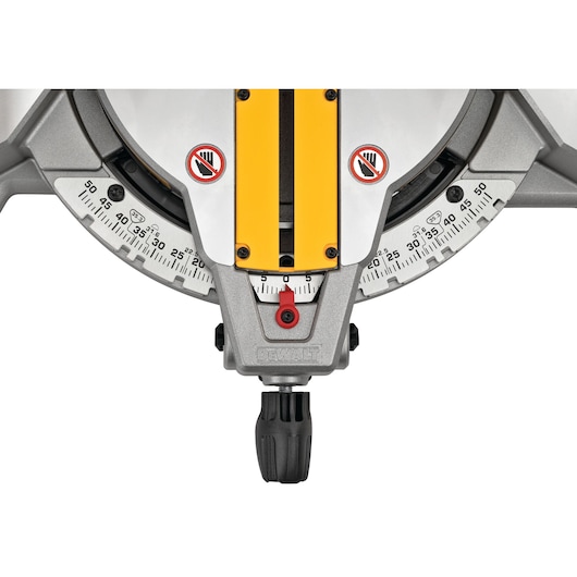 Close-up view of the angle adjustment gauge and handle of a DEWALT DWS713 compound miter saw, showing detailed markings for precise cutting angles and safety warning symbols.