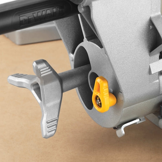 Close-up of a DEWALT DWS780 miter saw component, showing a silver handle and a yellow adjustment knob attached to the metal body.