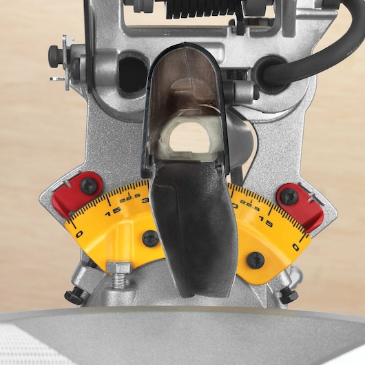 Close-up view of a DEWALT DWS780 miter saw showing the yellow angle measurement scale with red adjustment locks and metal components.