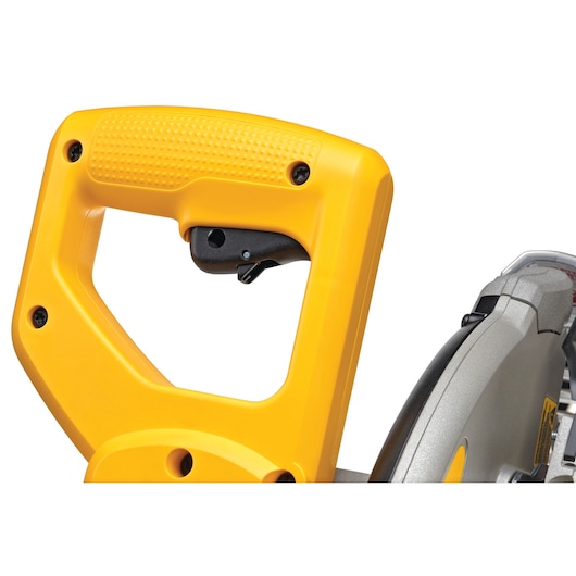 Close-up view of the yellow handle and trigger of a DEWALT miter saw, showing part of the saw blade and housing.