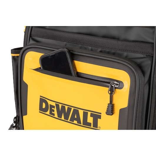 Close-up of a yellow and black DEWALT bag with a zippered front pocket, showing a smartphone partially tucked inside the pocket.