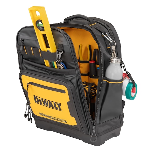 A DEWALT branded black and yellow tool backpack with multiple compartments, containing various tools such as a spirit level, pliers, screwdrivers, measuring tape, water bottle, and rolls of tape.